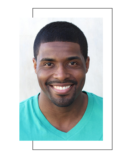 A smiling man with short hair wearing a blue t-shirt against a white background.