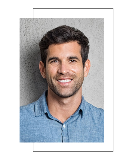 The image features a smiling man with short hair, wearing a blue shirt, standing against a grey background.